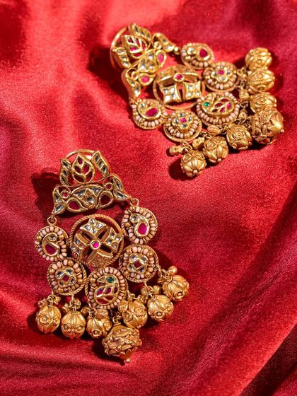 These antique gold earrings exude effortless sophistication. The intricate design with multi-tonal meenakari and gold bead drops goes beyond trends to offer timeless style.