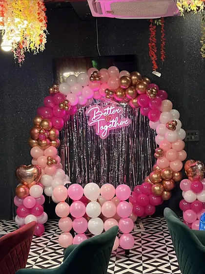 The pink and gold balloon arch in a cafe setting, showing how I can adapt my designs to different venues.