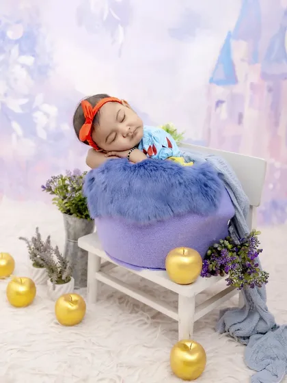 Our little Snow White, dreaming of a fairytale castle. Dressed in a classic costume and surrounded by golden apples, this themed newborn shoot is pure magic.