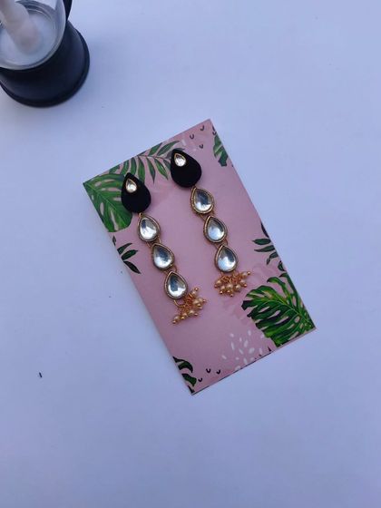 Long, dangling earrings made with drop-shaped Kundan pieces. These are elegant and perfect for a wedding reception or a formal party.