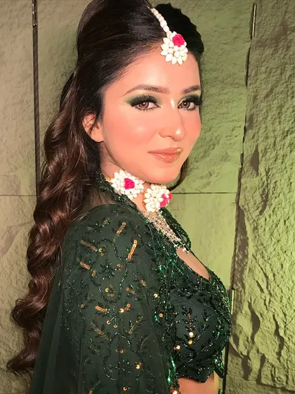 This angle highlights the beautiful floral jewelry and how it complements the green tones in the makeup and outfit.