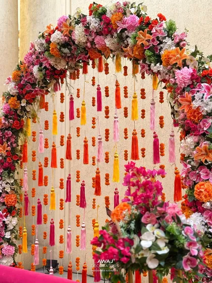 A detailed shot of the floral arch, showcasing the rich colors and textures of the flowers and tassels.