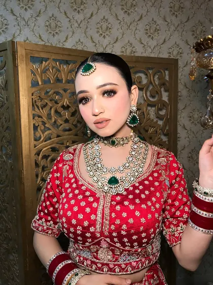 The bride's confident pose highlights the full impact of her styled look, from the jewelry to the lehenga.