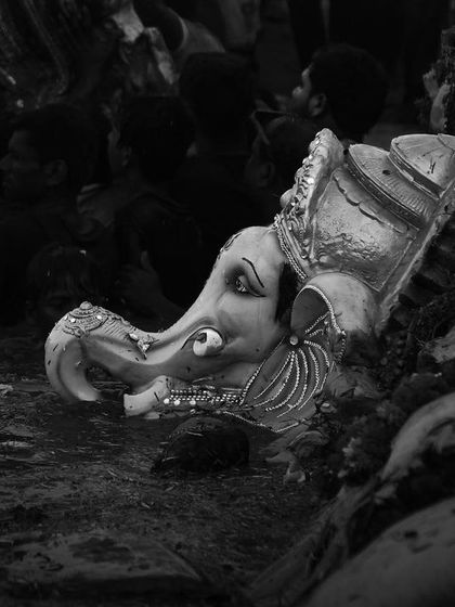 The head of a Ganesha idol floats in the water after immersion, a poignant black and white image that marks the end of the festival.