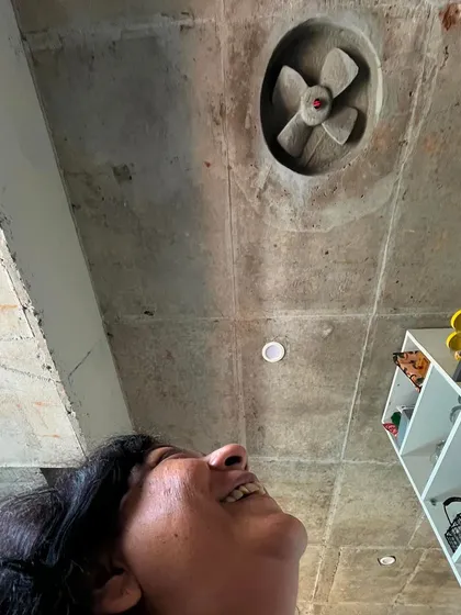 Looking up at the exposed concrete ceiling in artist Archana Hande’s studio. The space is filled with quirky, personal details that reflect her creative spirit, including a fan sculpted directly into the concrete.