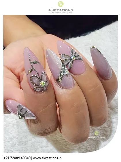 For a touch of luxury, I added these sculpted 3D floral and bow embellishments. Set against a soft pink base on long stiletto nails, these silver accents and rhinestones add dimension and high-end glamour.