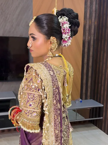 A side view of the bride in her purple Nauvari, highlighting her elegant updo and jewellery.