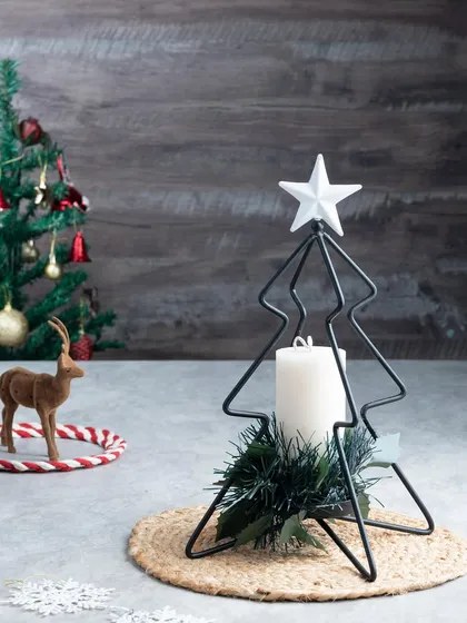 This wireframe Christmas tree stand holds a single pillar candle and is decorated with a bit of greenery. It's a lovely, simple decor piece.
