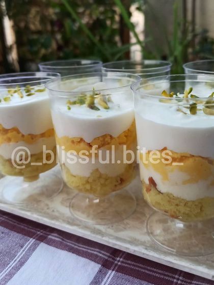 My Indian Rasmalai Fusion dessert, served in individual cups. This creative dessert features layers of cake and creamy rasmalai, topped with pistachios.