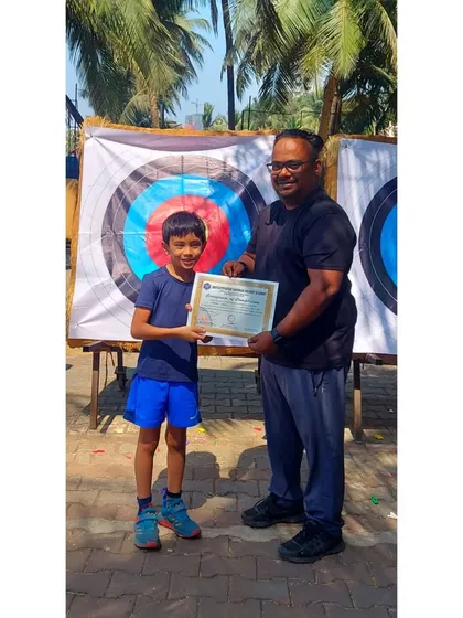 A young boy from the March 2023 batch, proudly holding his certificate of completion.