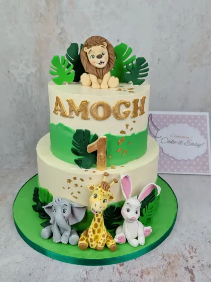 A jungle animal cake for a first birthday. This two-tier design features a lion, giraffe, elephant, and bunny, all handcrafted from fondant.