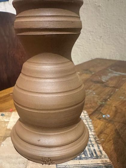 This unglazed piece shows the form and structure created during a pottery session, waiting to be fired and painted.