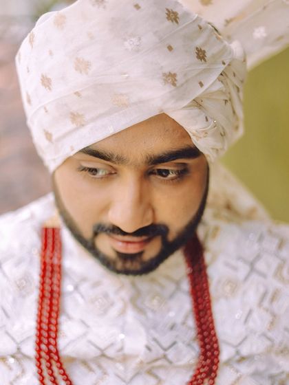 A close-up portrait of the groom, looking down. This quiet, contemplative shot shows a different side of the wedding day emotions.