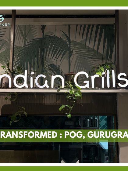 The neon sign for "Indian Grills" at the Pirates of Grill restaurant, with trailing plants artfully arranged around it. This small detail shows how greenery can be integrated with signage for a unique and memorable brand statement.