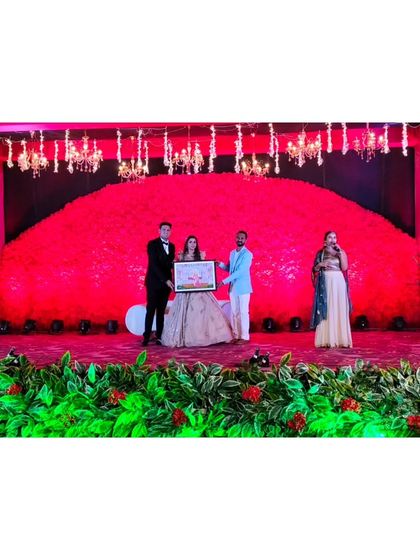 On stage, presenting the finished painting to the bride and groom during their reception. It's a unique gift that serves as a lasting memento of their wedding day.