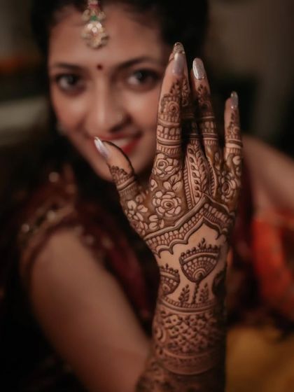 Bride Utsrini showing off her gorgeous mehendi. The design on the back of her hand is so elegant.