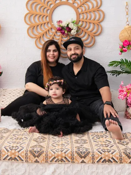 A stylish family portrait with a touch of drama. The family's all-black attire creates a chic and modern look against our decorated boho backdrop.