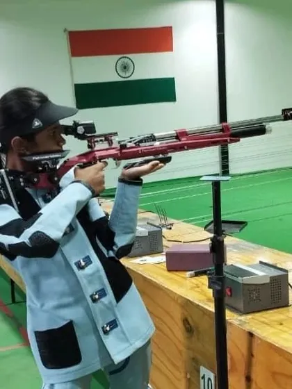 A student in full competition gear takes aim with a professional air rifle. We emphasize correct form, stance, and the use of proper shooting kits for peak performance.