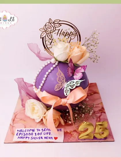 "Welcome to Season 25." A unique spherical cake in purple, decorated with butterflies, pearls, and fresh flowers to celebrate a silver birthday.