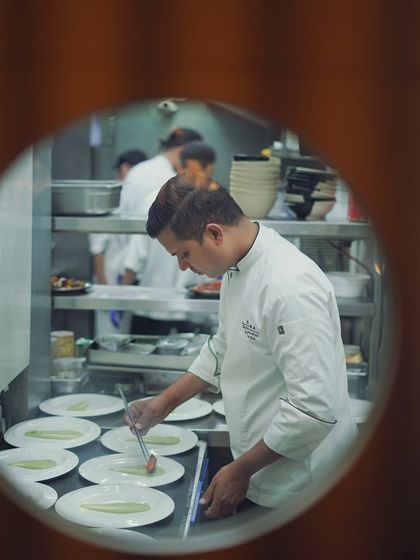 A peek into the kitchen during a busy service. Our chefs work with precision and focus to ensure every plate that leaves the kitchen is perfect.