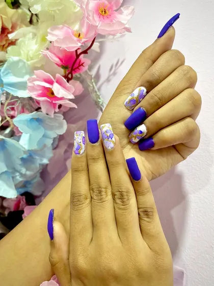 A royal purple matte set with a white and purple marble accent nail, decorated with gold foil.