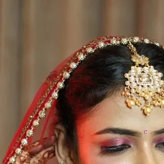A close-up on the bride's maang tikka and eye makeup. We capture the fine details of the bridal look.