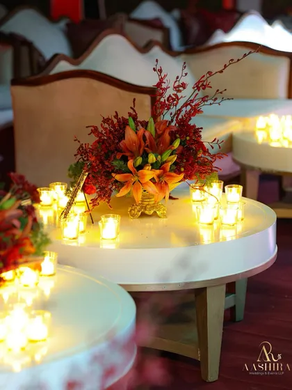 Another beautiful centerpiece with orange lilies and red foliage, surrounded by the soft, flickering light of numerous candles.
