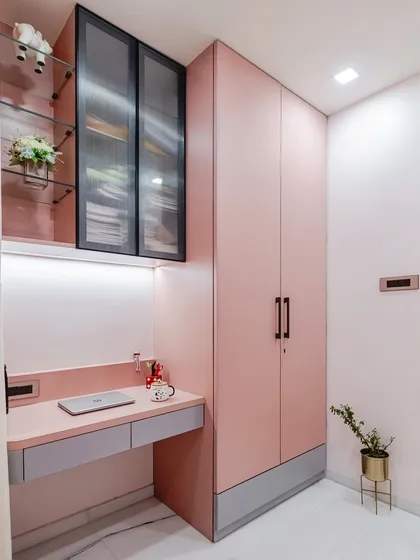 This view showcases how I integrate multiple functions into a single, cohesive unit. The dusty pink wardrobe, sleek study desk, and overhead storage work together to create a streamlined and organized space that feels both spacious and personal.