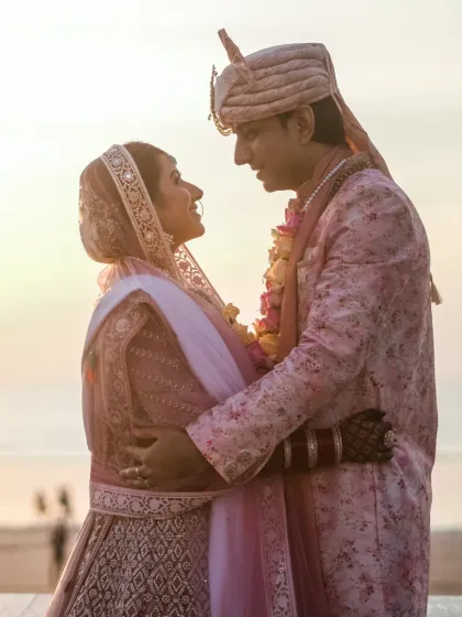 A romantic silhouette of a bride and groom against the evening sky, their faces close in a moment of quiet intimacy after their ceremony.