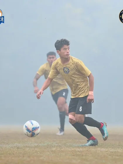 Eyes on the ball. A player advances with possession, looking for the perfect pass to unlock the defense.