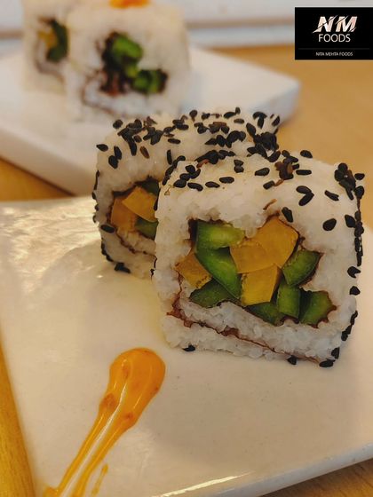A close-up of our vegetable sushi rolls, sprinkled with black sesame seeds. These rolls are filled with crisp, fresh vegetables, offering a light and healthy option for guests.