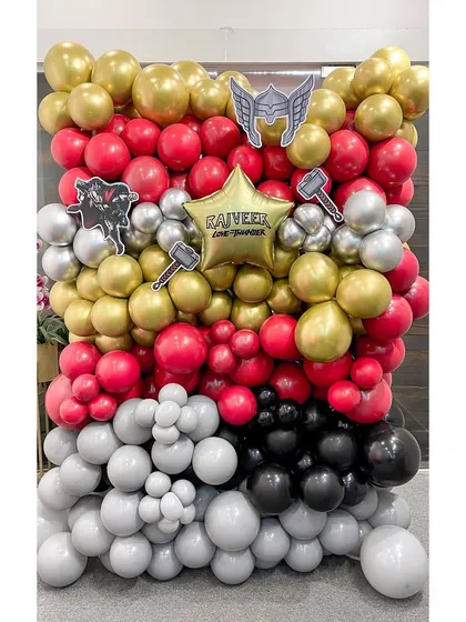 We assembled this powerful Thor-themed balloon wall using a color palette of red, gold, silver, and black. The backdrop is detailed with Thor's hammer and helmet cutouts and a personalized star balloon for the birthday boy, Rajveer.