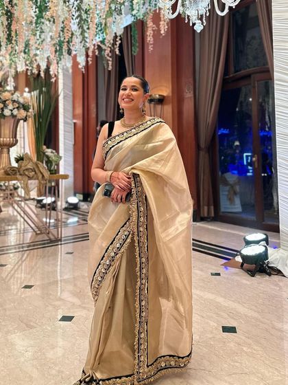 Posing in the grand venue, this picture shows how the elegant saree look fits perfectly within a luxurious wedding setting. It's all about feeling confident and beautiful.