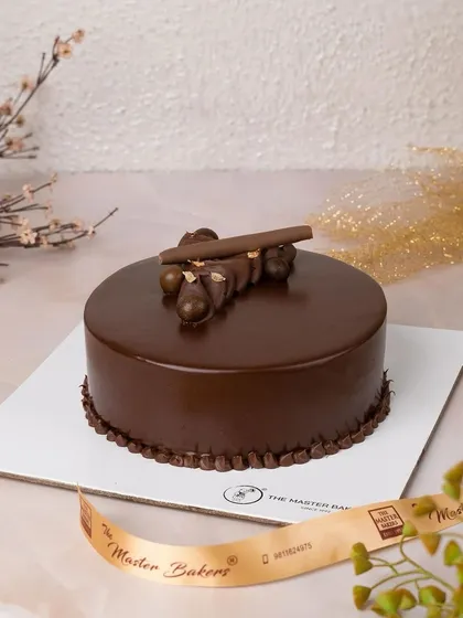 A simple yet decadent chocolate truffle cake, decorated with a small arrangement of chocolate pearls and sticks. It's a perfect example of how we let rich, high-quality ingredients speak for themselves.