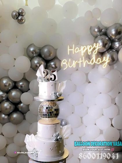 A close-up of a tiered cake for a 25th silver jubilee, set against a white and silver balloon wall. We can help coordinate cakes too.