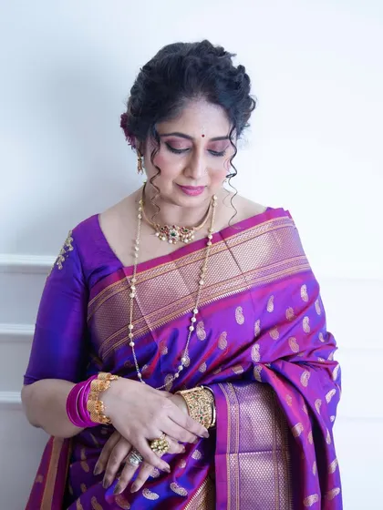 A close-up portrait celebrating Akshaya Tritiya. The focus here is on the rich purple Paithani saree and traditional gold jewelry, capturing a moment of quiet reflection and cultural significance.