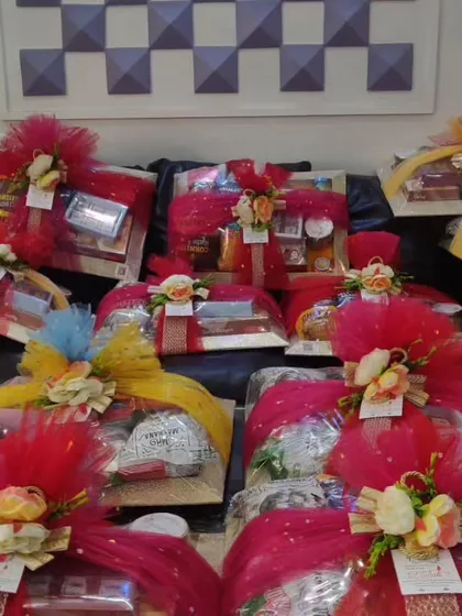 A collection of wedding hampers wrapped in bright red net with floral toppers, ready for a celebration.
