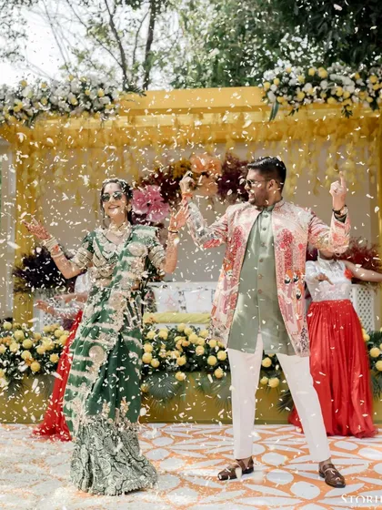 The couple dancing under a shower of confetti, a high-energy and joyful moment from their Haldi celebration.