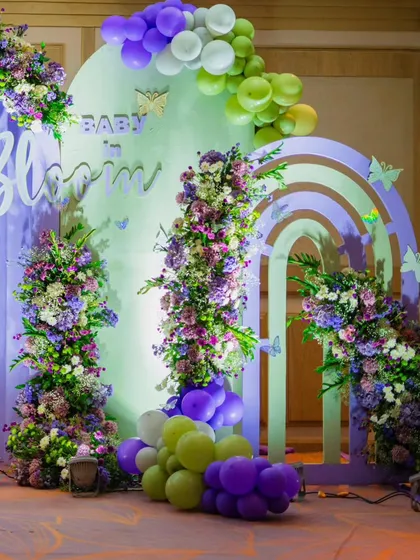 This 'Baby in Bloom' backdrop is one of my signature styles. I combine lush floral arrangements, soft pastel arches, and whimsical balloon garlands to create a picture-perfect setting for the mom-to-be. The rattan peacock chairs add a touch of bohemian opulence.
