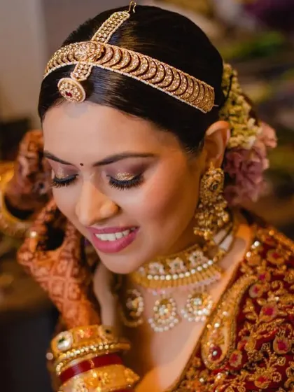 A smiling bride with a classic floral bun. The hairstyle is neat and allows her natural beauty and happiness to shine through.