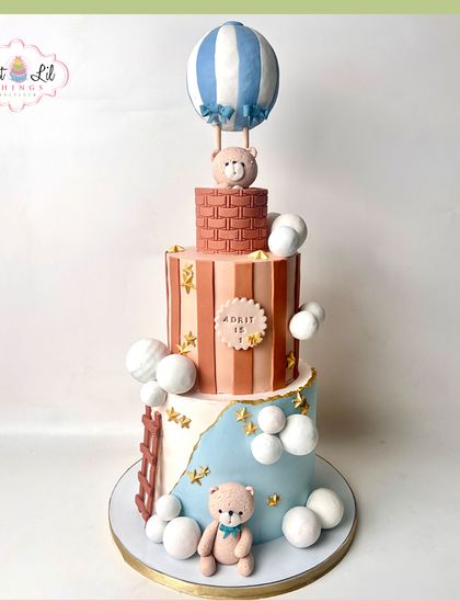 Up, up, and away! This charming three-tiered hot air balloon cake is perfect for a first birthday. It features cute teddy bears, soft clouds, and a lovely pastel color scheme for a gentle and dreamy celebration.