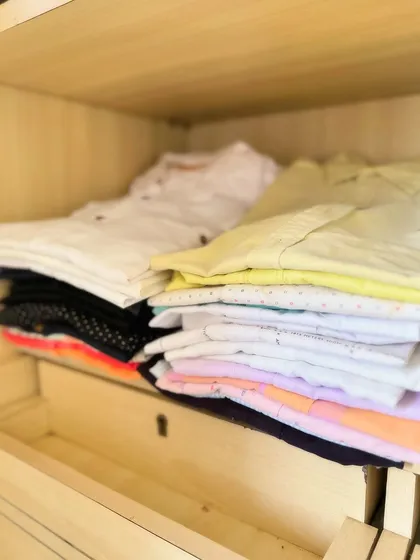 A simple stack of folded shirts. Even without complex organizers, proper folding and stacking can make a huge difference in keeping shelves tidy.