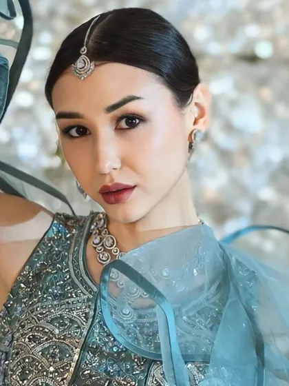 Another beautiful close-up, showcasing the model's flawless makeup and the elegant maang tikka and necklace.