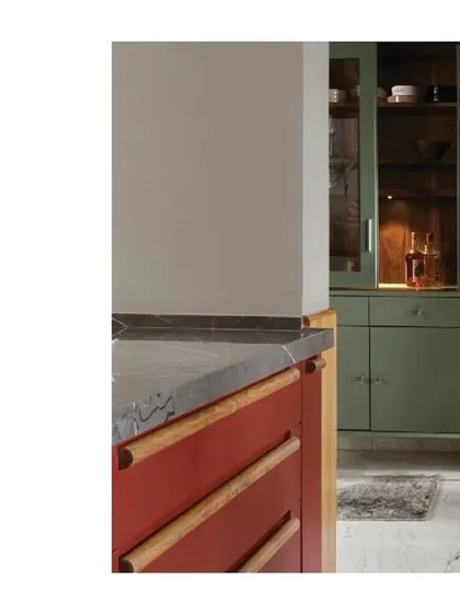 The contrast between the red cabinetry and the freestanding green crockery unit is a beautiful example of intentional color blocking. It shows how different pieces can speak to each other across a room to create a cohesive design narrative.