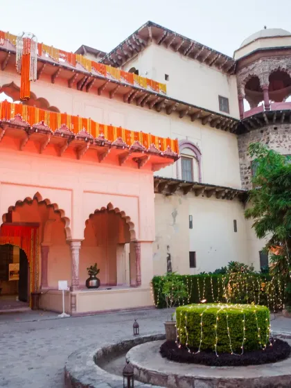 The exterior of Tijara Fort Palace decorated for a daytime wedding event. We used traditional marigold garlands and subtle lighting to highlight the architectural beauty of the fort, creating a vibrant and welcoming atmosphere for guests.