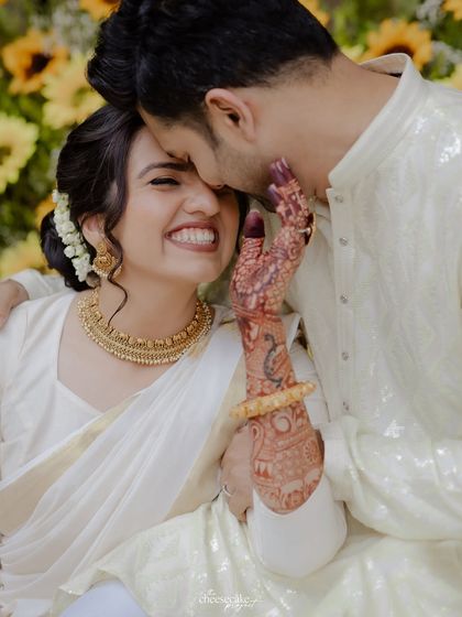 A close-up of the couple sharing a tender moment during their intimate Haldi, her beautiful mehndi on display.