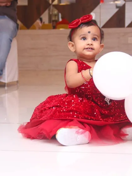 Candid photography from a first birthday party. I focus on capturing the genuine moments of wonder and fun, like this little one with her balloons, so you can enjoy the celebration.