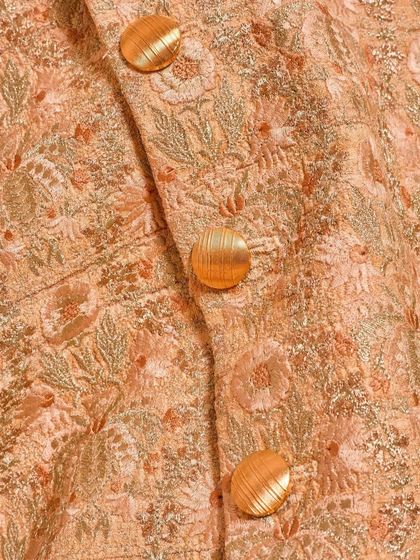 A close-up of the textured fabric and custom buttons on our floral embroidered sherwani. The combination of color and texture makes this a standout piece for any festive occasion.