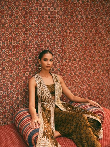 This look from the Anita Dongre campaign showcases Ajrakh block printing. The styling, with the layered jacket and relaxed pose, gives the traditional craft a contemporary, bohemian feel.