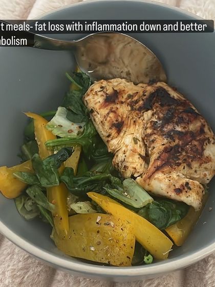 A client meal designed for fat loss, reducing inflammation, and boosting metabolism. This bowl features grilled chicken breast over a bed of sautéed spinach and yellow bell peppers.